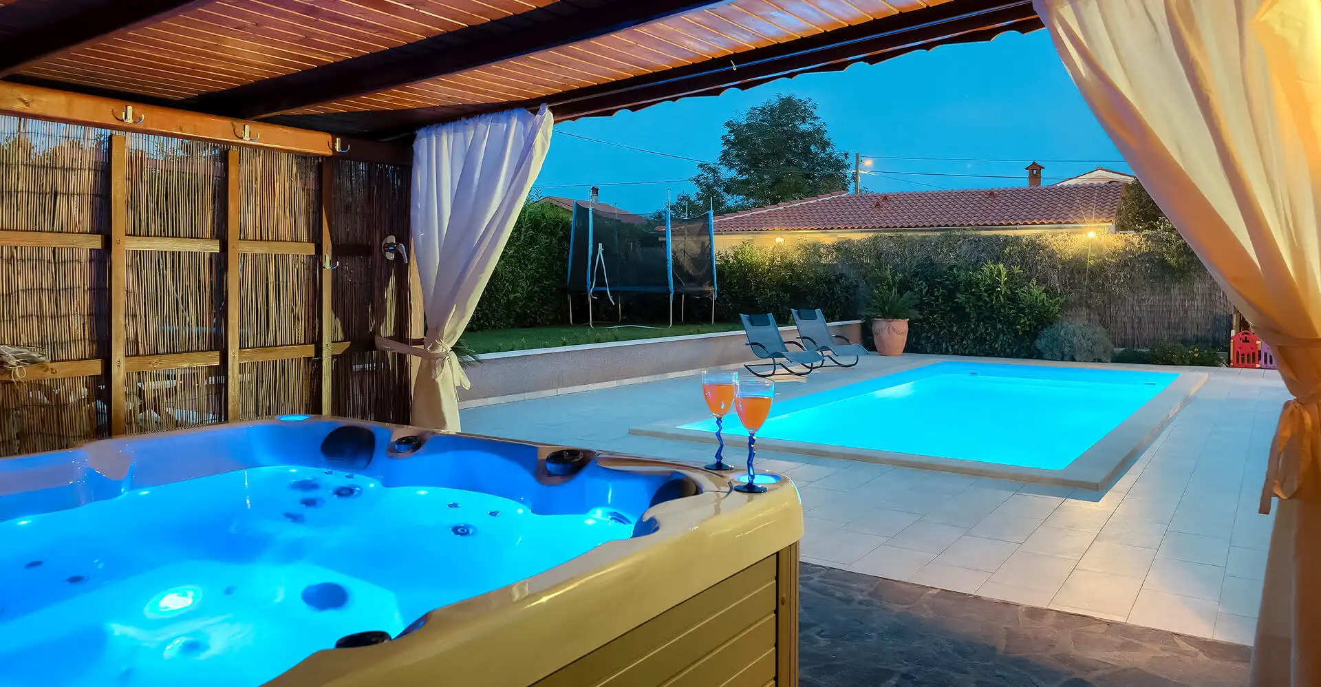 Covered terrace with private hot tub and view of the garden and pool at Villa Rasovic.